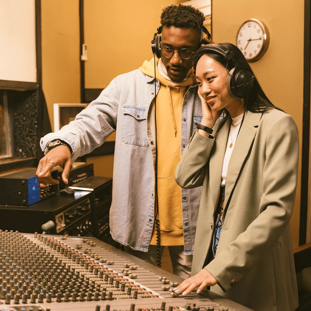 Two producers working together at a studio mixing console