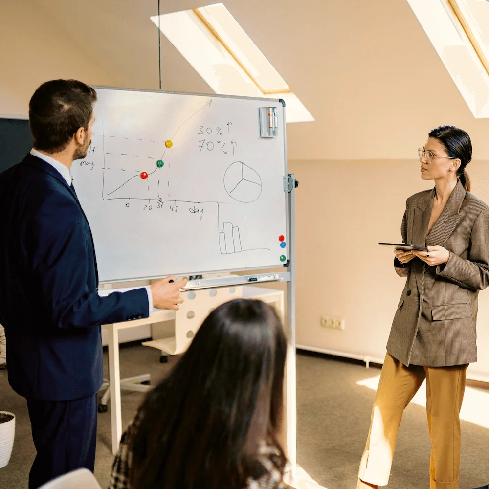 Colleagues planning together at an office whiteboard
