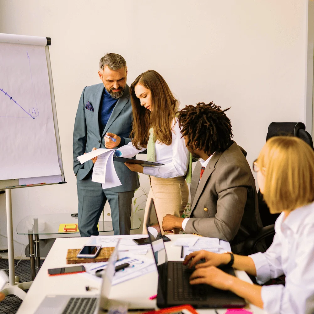 Consultant at a flip chart talking with a seated team
